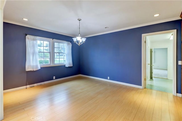 empty room with a notable chandelier, crown molding, and light wood-type flooring