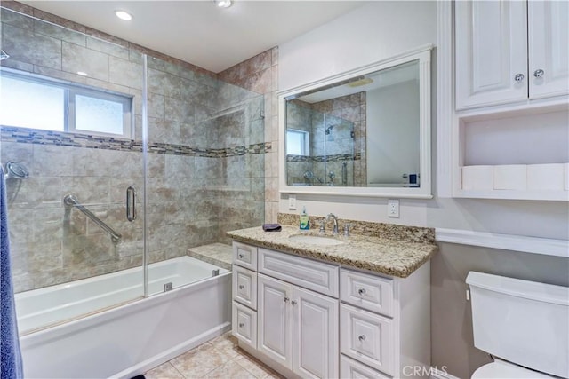 full bathroom with toilet, tile patterned floors, vanity, and shower / bath combination with glass door