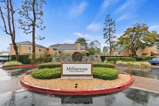 community / neighborhood sign featuring a residential view and fence