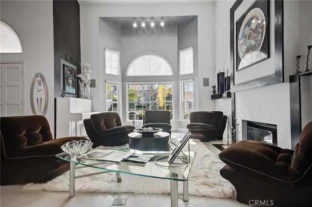 living room with a high ceiling and light tile patterned floors