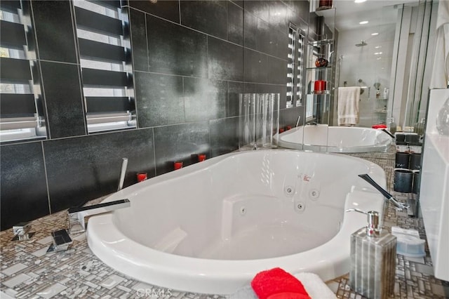 bathroom featuring a washtub and tile walls