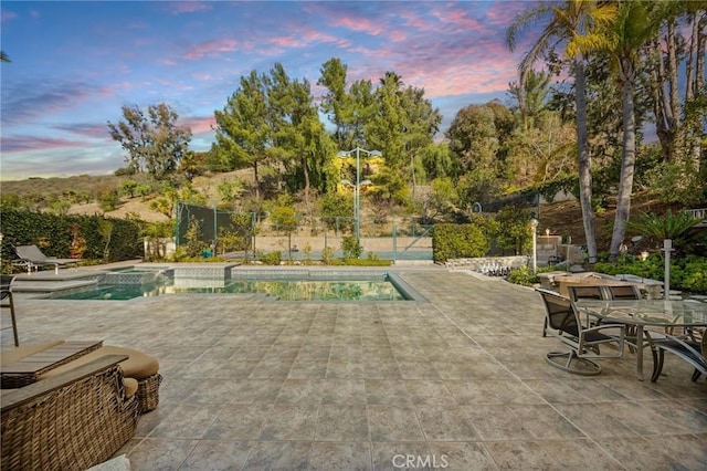 pool at dusk with a patio