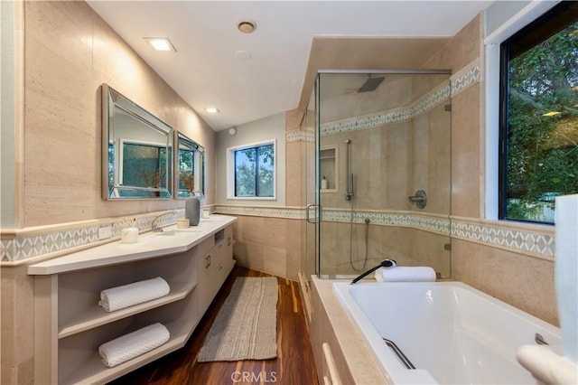 bathroom featuring vanity, plus walk in shower, and tile walls