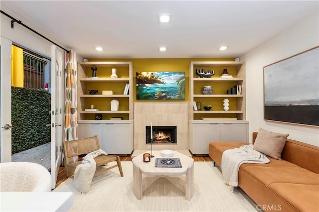 sitting room featuring built in shelves and a tiled fireplace