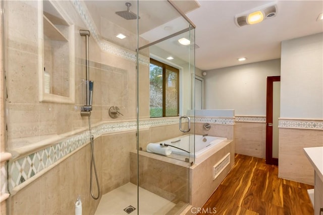 bathroom featuring vanity, separate shower and tub, hardwood / wood-style floors, and tile walls