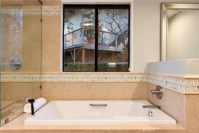 bathroom with a relaxing tiled tub