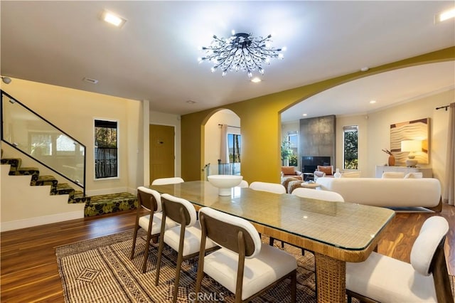 dining area featuring a notable chandelier, a wealth of natural light, and dark wood-type flooring