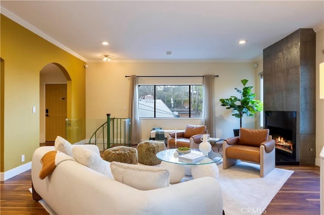 living room featuring crown molding, dark hardwood / wood-style floors, and a tile fireplace