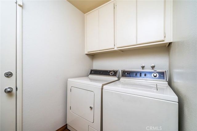 clothes washing area featuring cabinets and separate washer and dryer