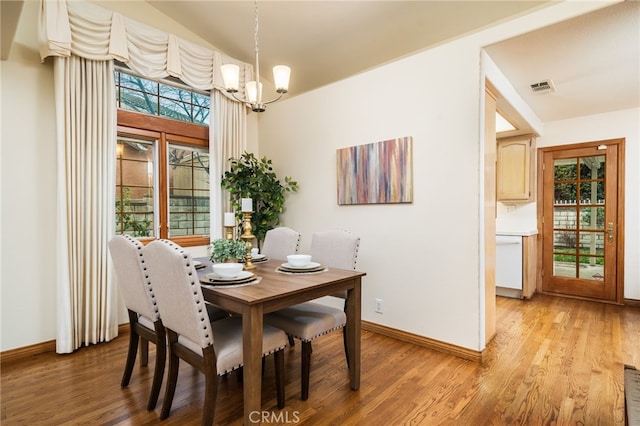 dining room with an inviting chandelier and light hardwood / wood-style flooring