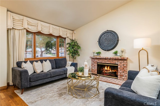 living room with high vaulted ceiling, hardwood / wood-style floors, and a fireplace