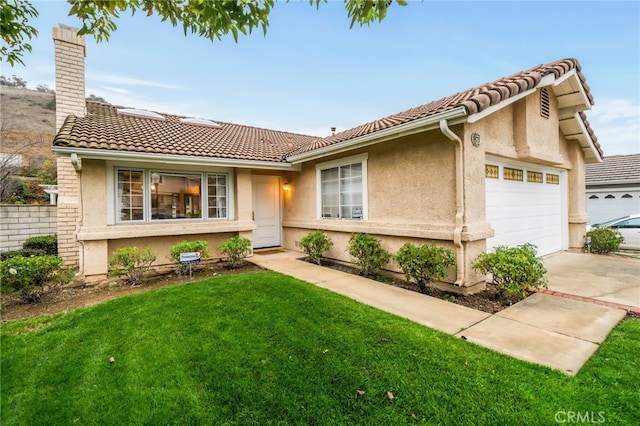 view of front of property featuring a garage and a front lawn