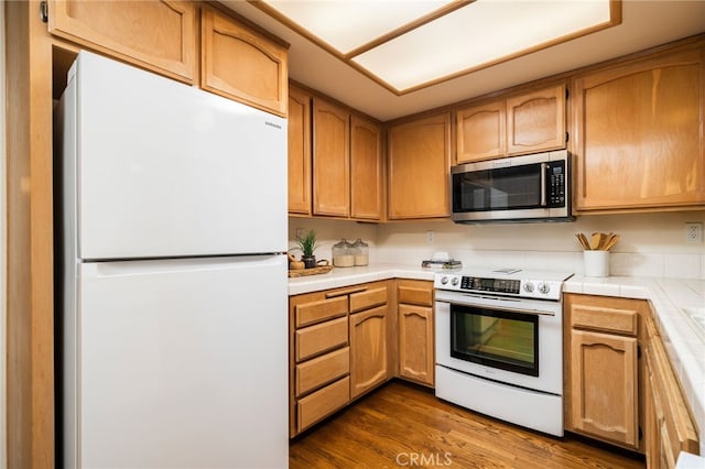 kitchen featuring white appliances, tile countertops, and dark hardwood / wood-style flooring