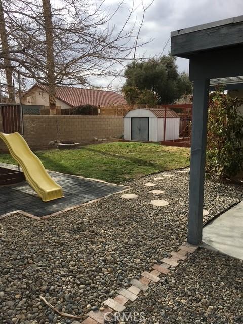 view of yard with a playground and a storage unit