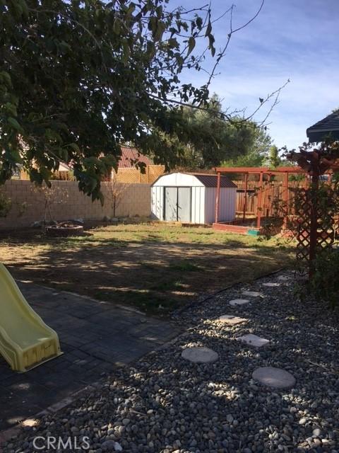 view of yard with a playground and a shed