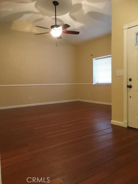 empty room featuring ceiling fan, dark hardwood / wood-style floors, and vaulted ceiling