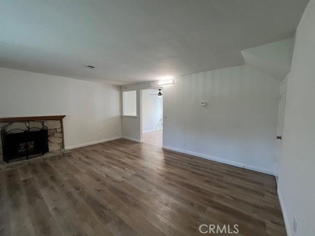 unfurnished living room with ceiling fan, dark hardwood / wood-style floors, and a fireplace