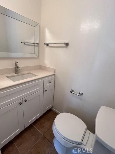 bathroom with tile patterned flooring, vanity, and toilet