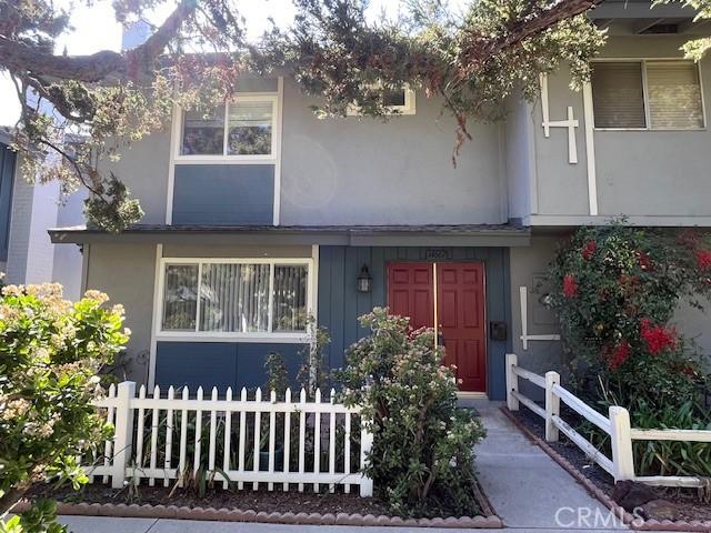 view of front facade featuring fence and stucco siding