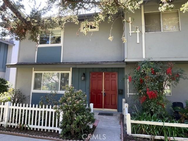 property entrance with fence and stucco siding