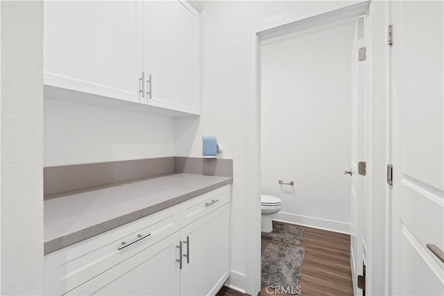 bathroom featuring baseboards, toilet, and wood finished floors