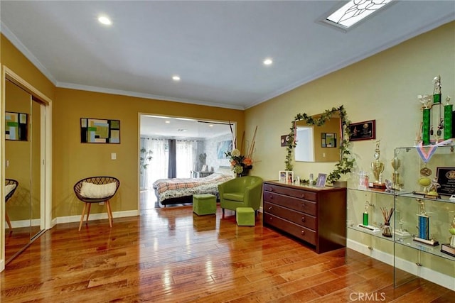 living area with ornamental molding, wood-type flooring, and a skylight