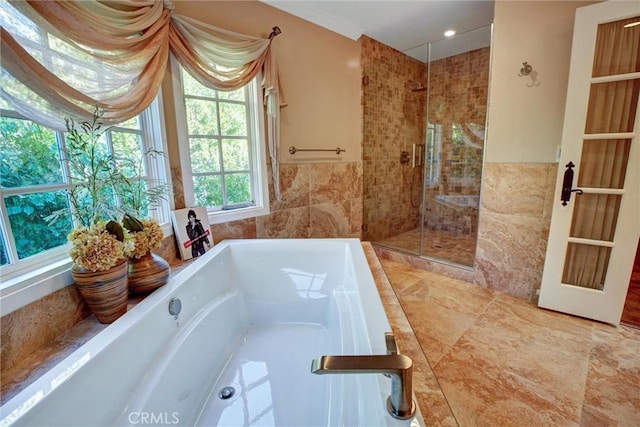 bathroom featuring tile walls and plus walk in shower