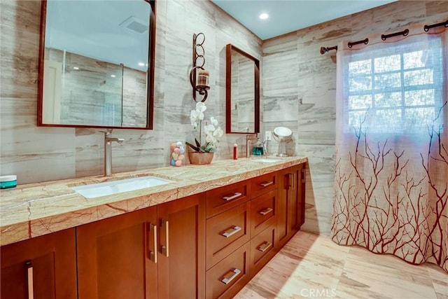 bathroom featuring vanity and tile walls