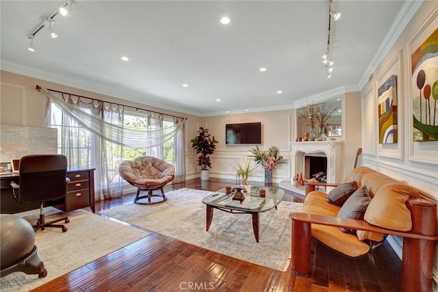 living room with crown molding, a wealth of natural light, track lighting, and light wood-type flooring