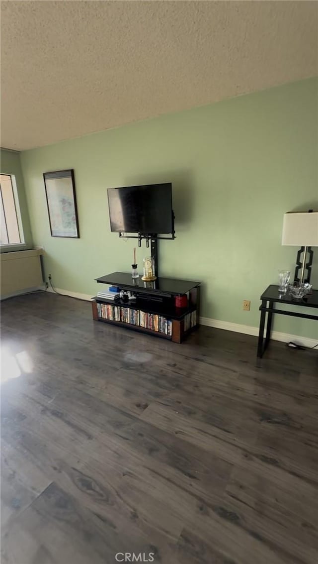 living room with dark wood-type flooring and a textured ceiling