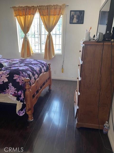 bedroom with dark hardwood / wood-style floors