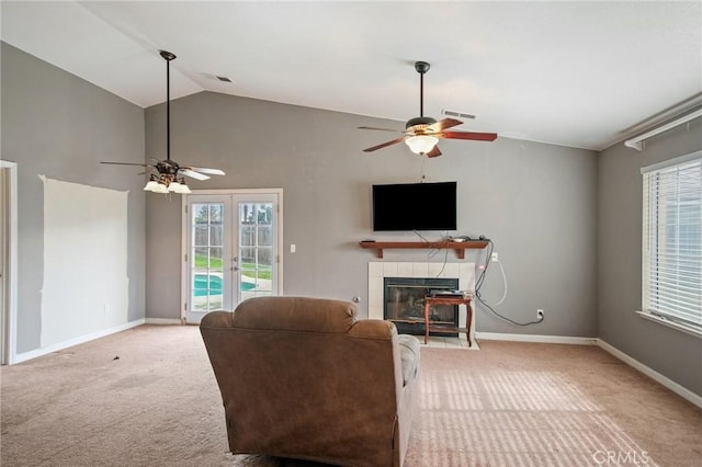 living room with light carpet, a tiled fireplace, lofted ceiling, and ceiling fan