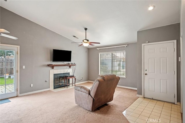 living room with ceiling fan, lofted ceiling, a fireplace, and light colored carpet