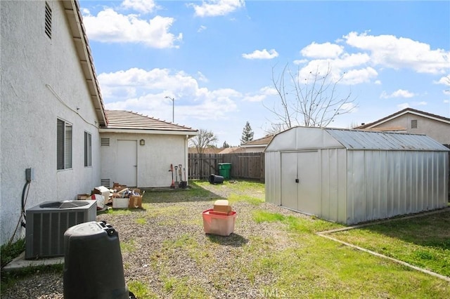 view of yard featuring a shed and central AC