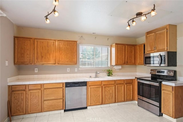 kitchen featuring appliances with stainless steel finishes, tile countertops, and sink