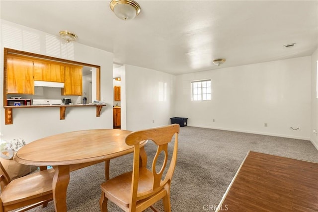 dining area featuring dark colored carpet