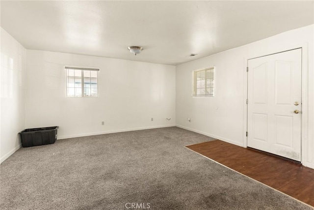 unfurnished room featuring dark colored carpet