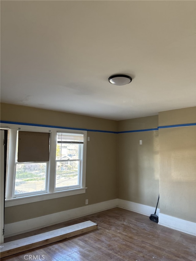 empty room featuring baseboards and wood finished floors