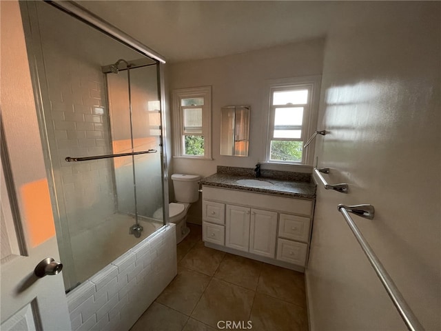 full bath featuring tile patterned floors, toilet, tiled shower / bath combo, and vanity