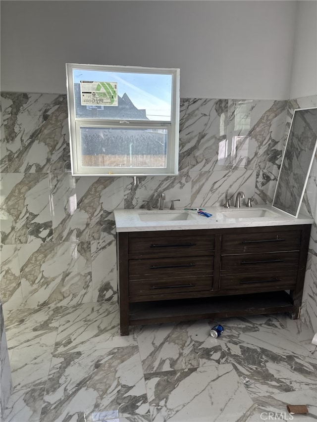 bathroom with double vanity, marble finish floor, and a sink