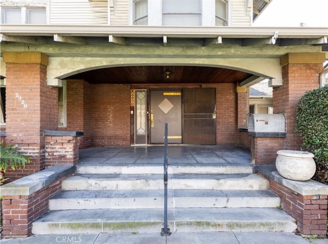 doorway to property with brick siding and an attached garage