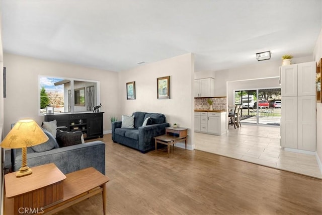 living area featuring light wood-style flooring and baseboards