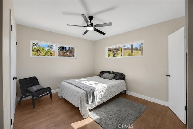 bedroom featuring dark wood-style floors, ceiling fan, and baseboards