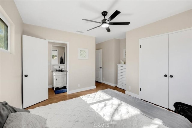 bedroom featuring a closet, visible vents, ceiling fan, light wood-type flooring, and baseboards