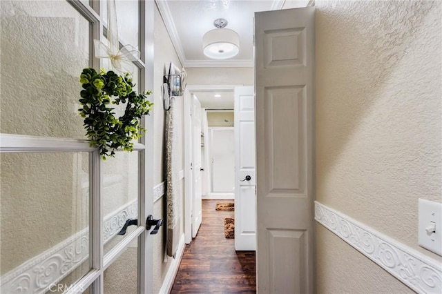 hall with crown molding, dark wood-style flooring, and a textured wall