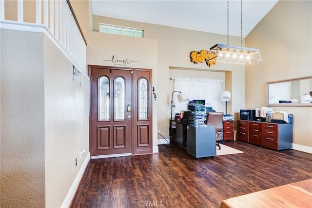 foyer entrance featuring high vaulted ceiling, dark wood-style flooring, and baseboards