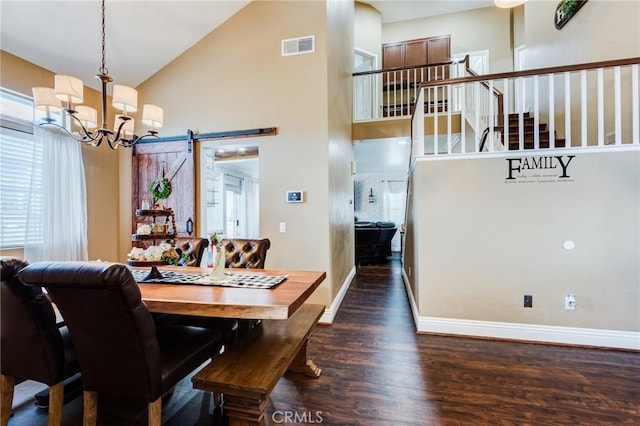 dining space featuring high vaulted ceiling, a barn door, wood finished floors, visible vents, and stairs