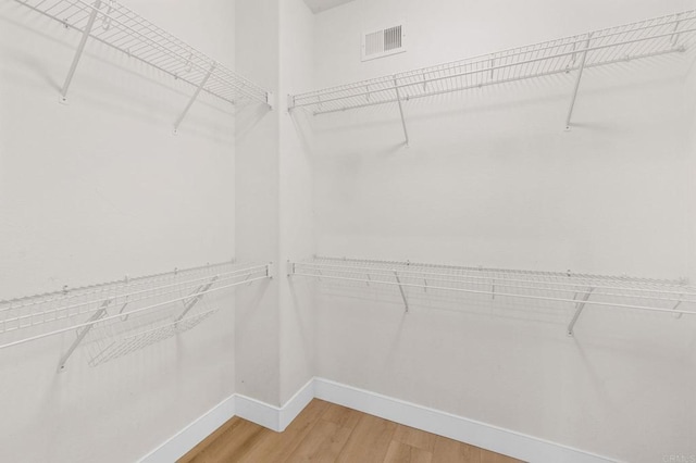 walk in closet featuring wood finished floors and visible vents