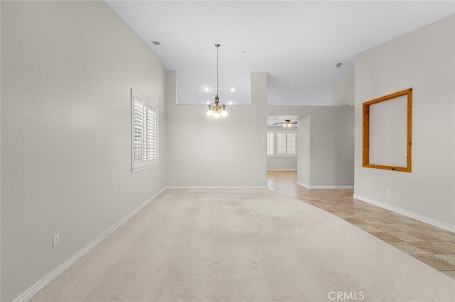 spare room with visible vents, vaulted ceiling, light carpet, and baseboards