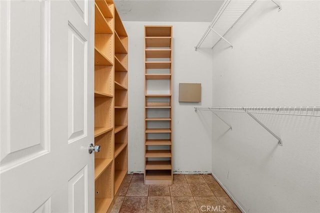 spacious closet featuring dark tile patterned floors